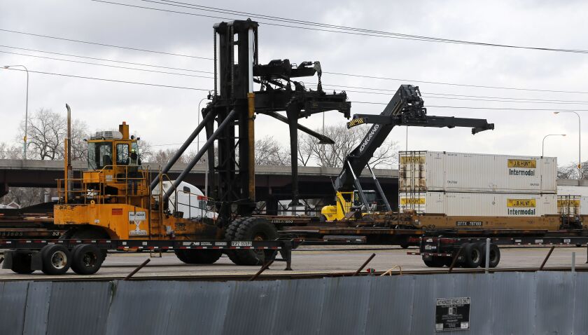 Containers are unloaded from a rail car in February in the Norfolk Southern rail yard next to Rev. Corey Booker’s New Beginnings Church in Chicago. | AP