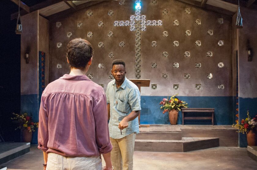 Paul (Kai A. Ealy, background) confronts Chris (Kearstyn Keller) over her motives in returning to Uganda and the church, 14 years after she left in TimeLine Theatre’s production of “Cardboard Piano.” | Lara Goetsch