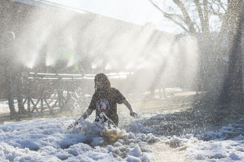 Marist High School students run through a specially-designed “polar cannon” as a coronavirus-safe Polar Plunge alternative on Tuesday. Around 100 students participated.