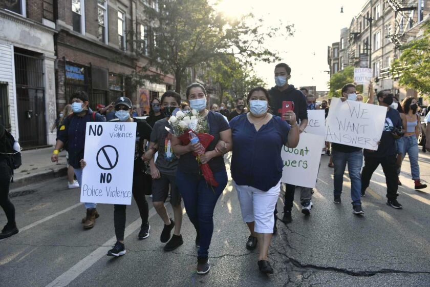 Family of Miguel Vega march on 18th Street with supporters Saturday in Pilsen.