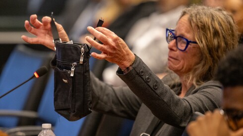 Jennifer Moriarty shows the purse a federal agent cut off her body while she was handcuffed during a hearing before the Illinois Accountability Commission at the Michael A. Bilandic Building in downtown Chicago, Monday, April 27, 2026.