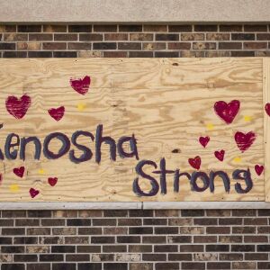 Members of the community paint over the boarded up windows of businesses near 57th Street and 7th Avenue as the city of Kenosha prepares fo the fourth day of civil unrest after police shot Jacob Blake, Wednesday evening, Aug. 26, 2020.
