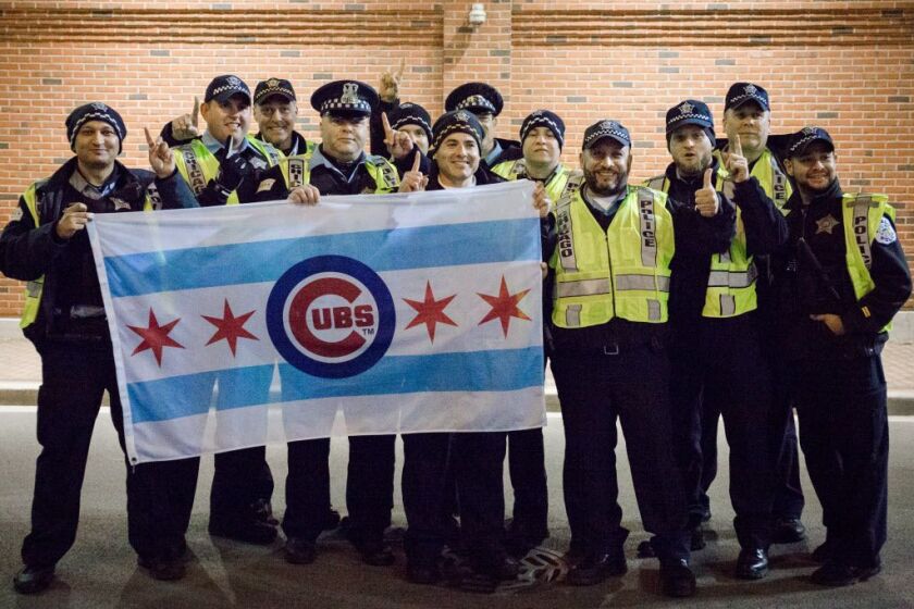 Police officers showed their support for the Cubs outside Wrigley Field during Game 5 of the World Series on Sunday. | Santiago Covarrubias / Sun-Times