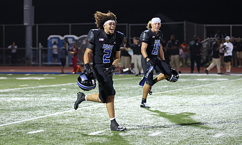 Lincoln-Way East's Jayden Cawthon (2) and Lucca Merritt (15) celebrate after the Griffins come from behind in the fourth quarter to defeat Brother Rice 22-21.