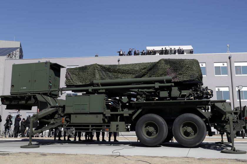 U.S. Vice President Mike Pence, top center, inspects a PAC-3 interceptor missile system with Japanese Defense Minister Itsunori Onodera, top center left, at Defense Ministry in Tokyo on Wednesday. | AP photo