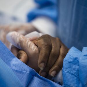 Nurse practitioner Capri Reese talks to a patient and holds her hand while a doctor administers an IV at Roseland Community Hospital on the Far South Side, Tuesday afternoon, April 28, 2020. During Reese’s standard 12-hour shift Tuesday, she responded to five code blues and three patients suffering from the coronavirus died.