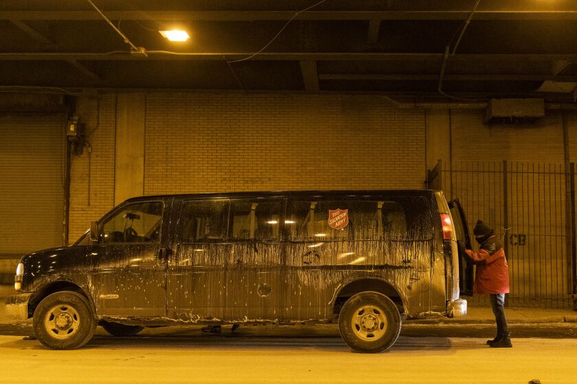 Workers from the Salvation Army stop their van on Lower Wacker Drive near a tent set up by a homeless man.
