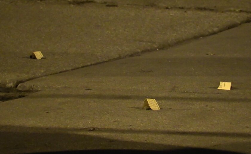Police mark shell casings from the shooting in the 5000 block of South Drexel. | Network Video Productions