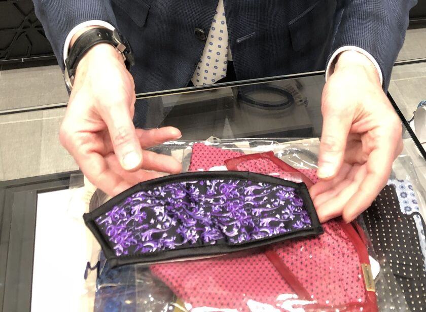 Scott Shapiro, son of the founder of Syd Jerome, the upscale Loop men’s store founded by his father Sidney, shows off one of the $85 face masks made by Italo Ferretti, which also made the necktie he’s wearing.