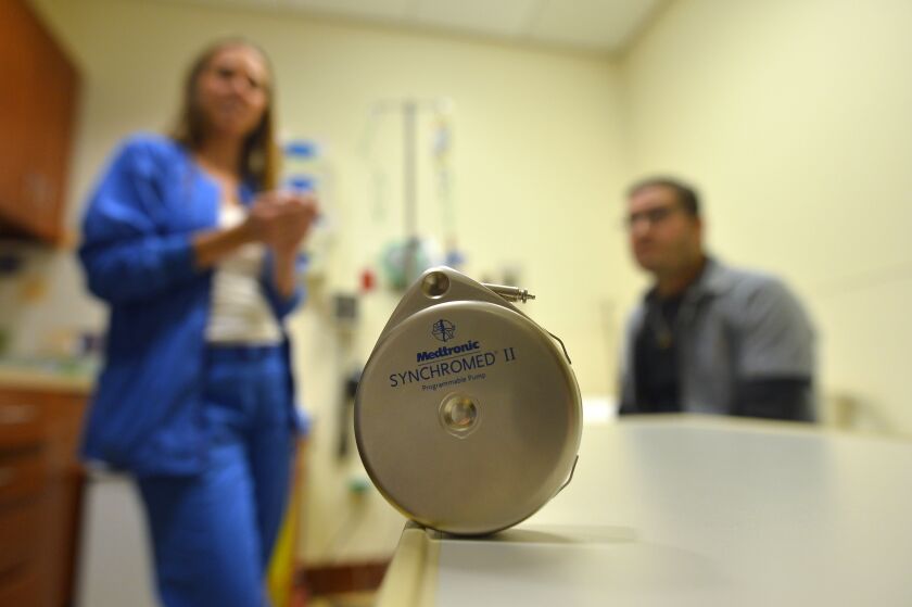 A hepatic artery infusion pump in Sean O’Reilly’s abdominal delivers high-dose chemotherapy directly to the liver through a large artery, the hepatic artery. O’Reilly (right) and oncology nurse Caroline Castino prepare for the procedure at the Robert H. Lurie Comprehensive Cancer Center of Northwestern University.