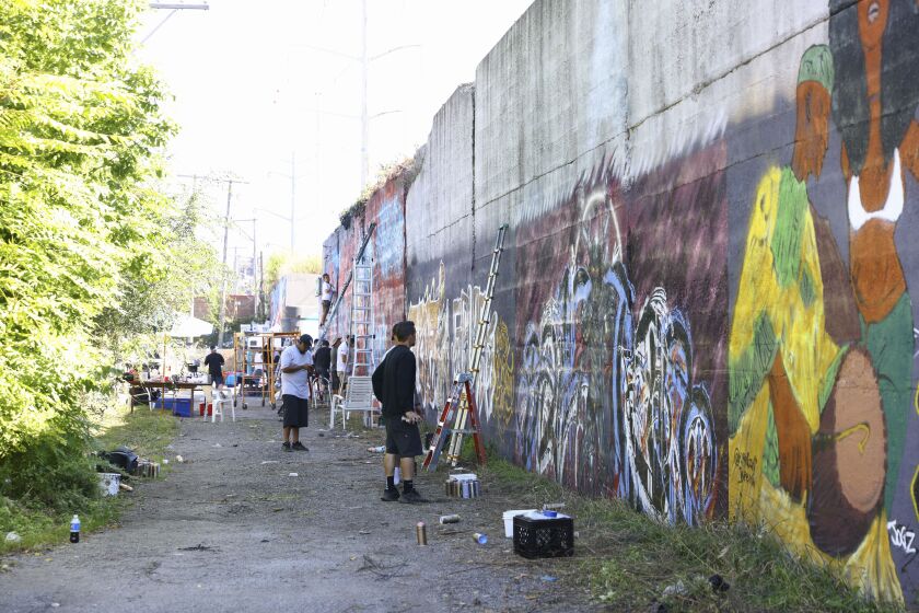 Artists work on different pieces of work Sunday at the “Meeting of Styles,” an international street art festival near Commercial and South Chicago avenues on the Southeast Side.