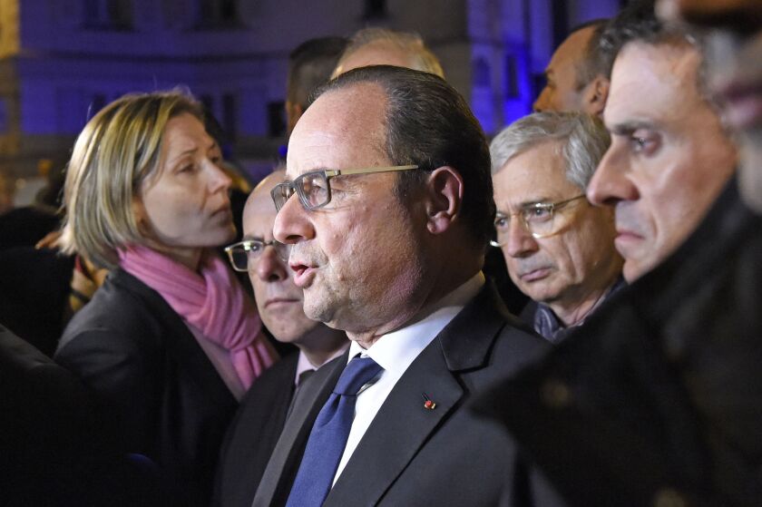 French President Francois Hollande (center), flanked by French Interior Minister Bernard Cazeneuve (left rear), French Prime Minister Manuel Valls (right) and President of the French National Assembly Claude Bartolone addresses reporters near the Bataclan