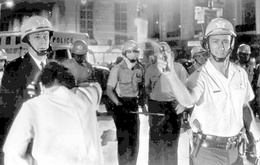 A Chicago police officer sprays mace into a crowd as police try to break up demonstrations surrounding the Democratic National Convention in 1968. | Paul Sequeira / Chicago Daily News