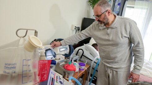 Mahmoud attends to some of the medical devices used by his disabled son Omar
