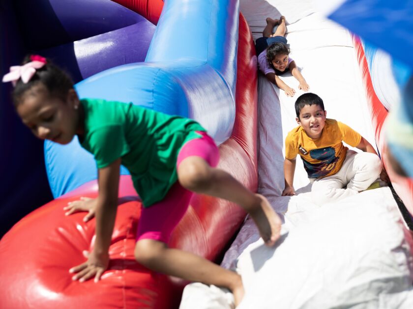 Carlos Juarez, a second-grade student at Florence Nightingale Elementary School, slides down a blow-up slide during a Chicago Public Schools back-to-school bash in Davis Square Park on the South Side, Friday, July 21.