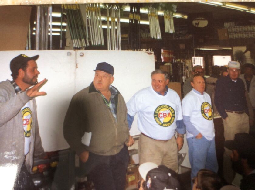 L-R Showing the drawing power of the Chicagoland Bank Anglers, most of the crew of the late Frank “Pan Man ” DeFrancisco, Frank Brzycki, Ron Bridges, Ken Schneider, and the late Chuck Thompson sported Chicagoland Bank Anglers shirts before a presentation at Henry’s Sports and Bait.