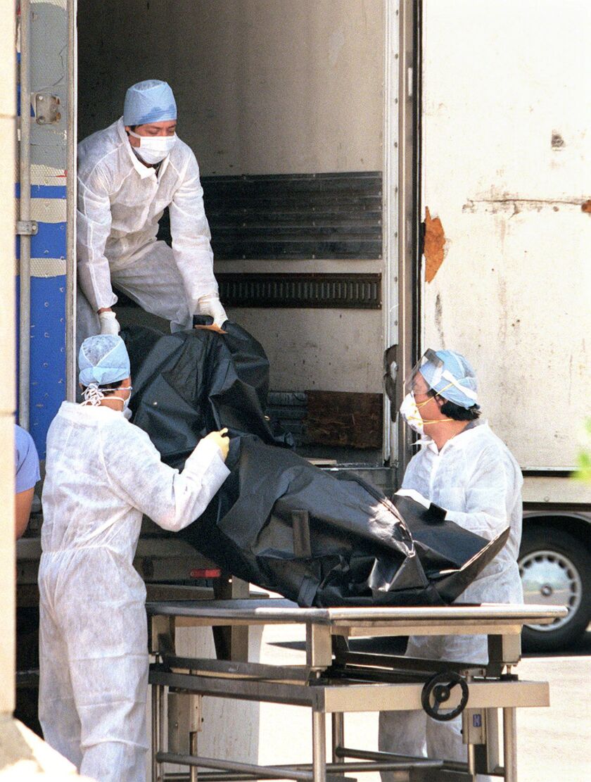 Cook County medical examiner’s office workers load bodies into a refrigerated truck in the parking lot of the Chicago’s county morgue during the heat wave of 1995. Sun-Times file photo