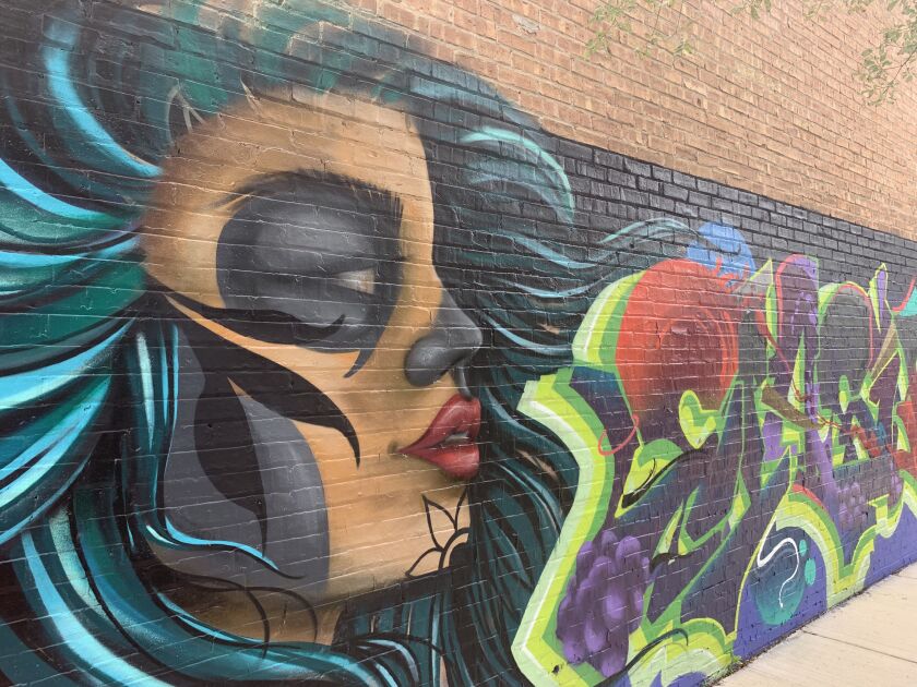 A woman painted by artist Josh “Classics” sits at the center of the mural at 3389 N. Milwaukee Ave.
