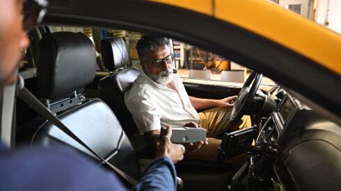 A city inspector passes a certified taximeter to Chicago cab driver Bob Singh inside his minivan during a vehicle inspection to renew his medallion at the city vehicle inspection facility on West Pershing Road in Chicago, on Tuesday, June 16, 2026.