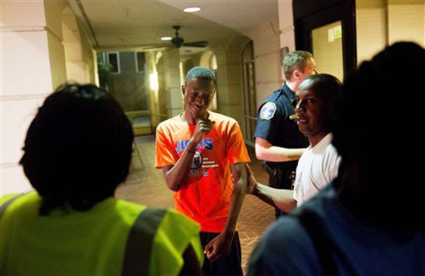 A distraught man is comforted as a group of concerned people arrive, inquiring about a shooting across the street at the Emanuel AME Church on Wednesday evening in Charleston, S.C. | David Goldman/AP