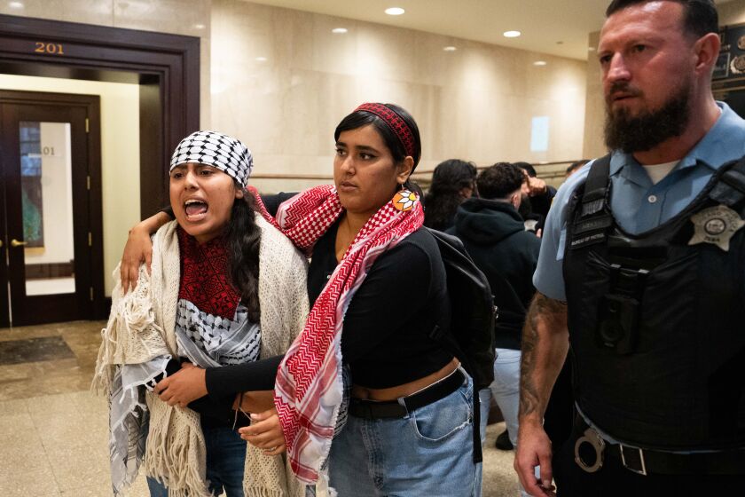 Supporters of Palestine, opposed to a resolution backed by Ald. Debra Silverstein to condemn a Hamas attack on Israel are escorted out of the City Council chambers by police on Oct. 13, 2023.