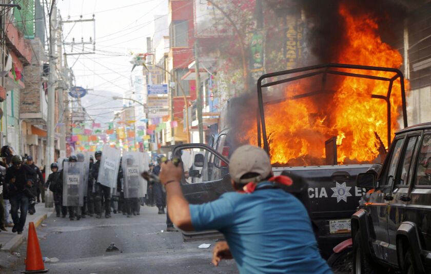 A demonstrator throws stones at the police in 2015 in Mexico during a protest over the disappearance of 43 students.