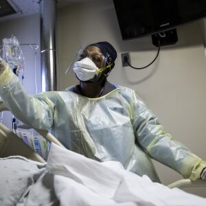 Nurse Jessica Bell administers sedative medication for a man with COVID-19 and on a ventilator in the Intensive Care Unit at Roseland Community Hospital on the Far South Side, Tuesday afternoon, Dec. 8, 2020.