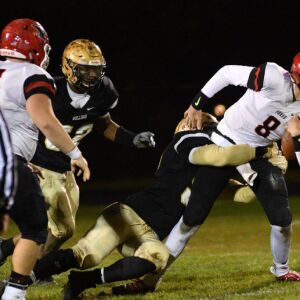 Yorkville’s QB Josh Beetham (8) gets pulled down. Worsom Robinson/For the Sun-Times.