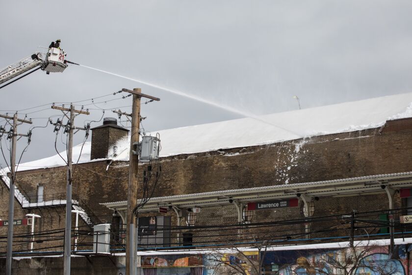 Chicago Fire Department firefighters spray water on the roof of the Aragon Ballroom to knock loose at least a foot snow that had accumulated and damaged a brick wall on the North Side building Tuesday.