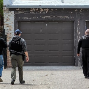 Officers inspect a backyard in the 2600 block of West Carmen Avenue.