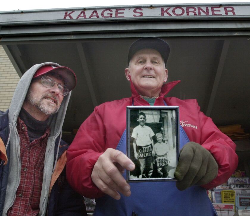 Irv Kaage Jr. (right) with his son Michael Kaage in November 2002 at Kaage’s Corner, the Edison Park newsstand where at that point he’d been selling newspapers and magazines for over 60 years. That’s Michael at age 5 and his older brother Irv Kaaage III in the photo the father’s holding.