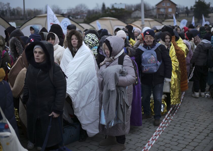 Refugees wait in a crowd for transportation after fleeing from the Ukraine and arriving at the border crossing in Medyka, Poland, on March 7, 2022.