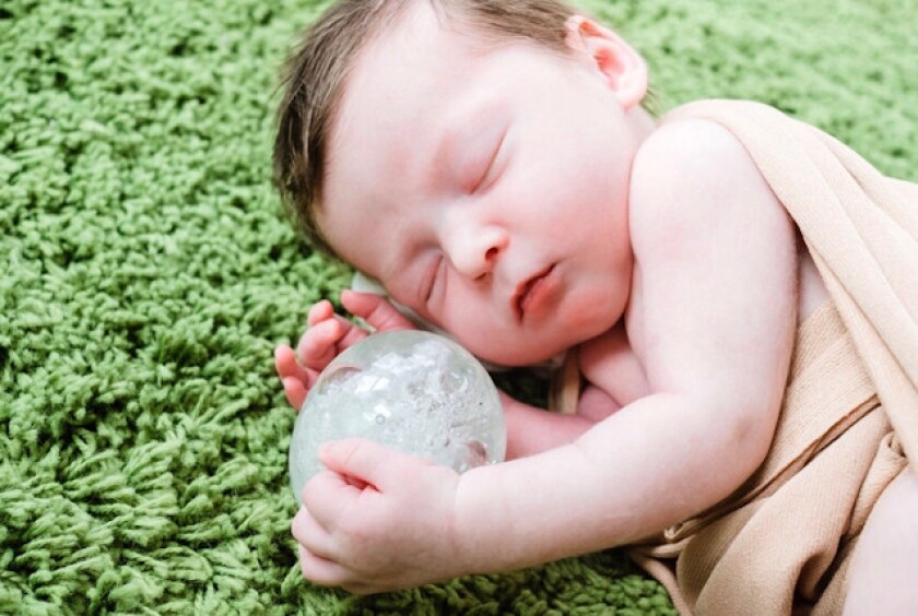 Sparrow Scott is photographed next to a paperweight made with some of the cremated remains of her brother Arrow, who died at birth. Their parents Roberta and Sean Scott commissioned glassblower Jeff Blandford to create the keepsake.