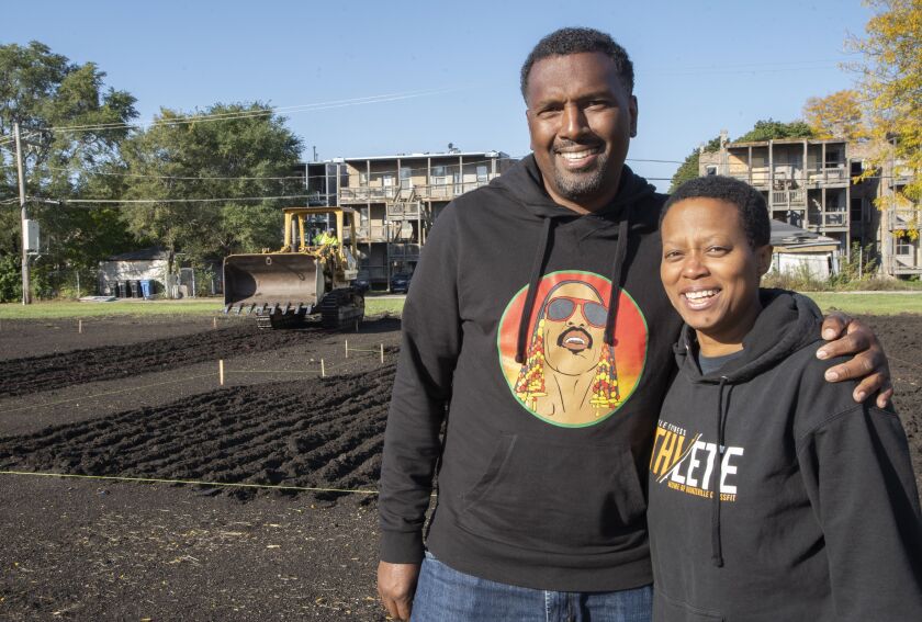 Chicago artist Amanda Williams, right, and Ghian Foreman, president and CEO of the Emerald South Economic Development Collaborative, in front the Washington Park lots before they were planted with tulips as part of Williams’ work “Redefining Redlining.”