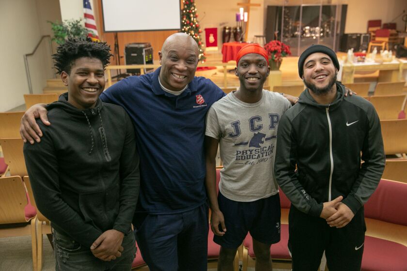 (From left to right) At the Salvation Army Red Shield Center in Englewood, mentee Carl Velez, 21, Corps Ministries Director Theo Coleman, and mentees Isaac House, 18, and Jaridian Lee, 19, gather for the Celebrate Launch and Landing mentoring program held