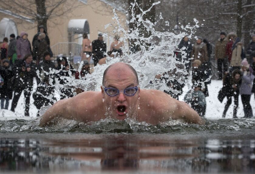 A Russian man swims in the icy water marking the 71st anniversary of the breaking the Nazi siege of Leningrad during WWII, in St. Petersburg, Russia, Sunday, Jan. 25, 2015. The temperature in St. Petersburg is around -3 C (27 F). (AP Photo/Dmitry Lovetsky