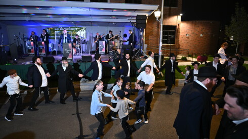 Dancers form a circle in the street Monday night, Sept. 28, 2026 during "Dancing in the Streets" outside Congregation Bnei Ruven in West Ridge. It's part of Simchas Beis Hashoeva, which is celebrated during the Jewish holiday of Sukkot, which marks harvest season.