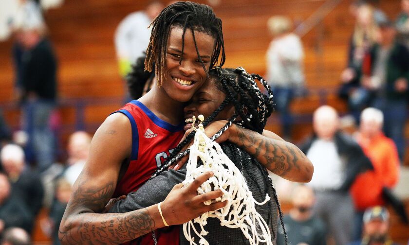 Curie’s Ramean Hinton hugs his mom after the Condors win the Pontiac Holiday Tournament and he was named the A.C. Williamson award winner.