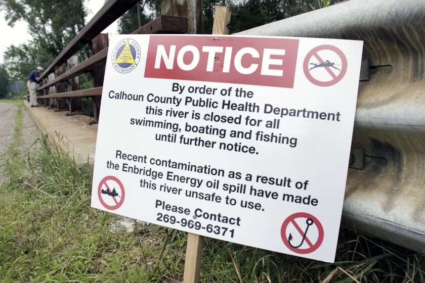 A sign is posted on a bridge to indicate water contamination after an oil spill of approximately 800,000 gallons of crude in the Kalamazoo River July 28, 2010 in Marshall, Michigan. (Photo by Bill Pugliano/Getty Images)