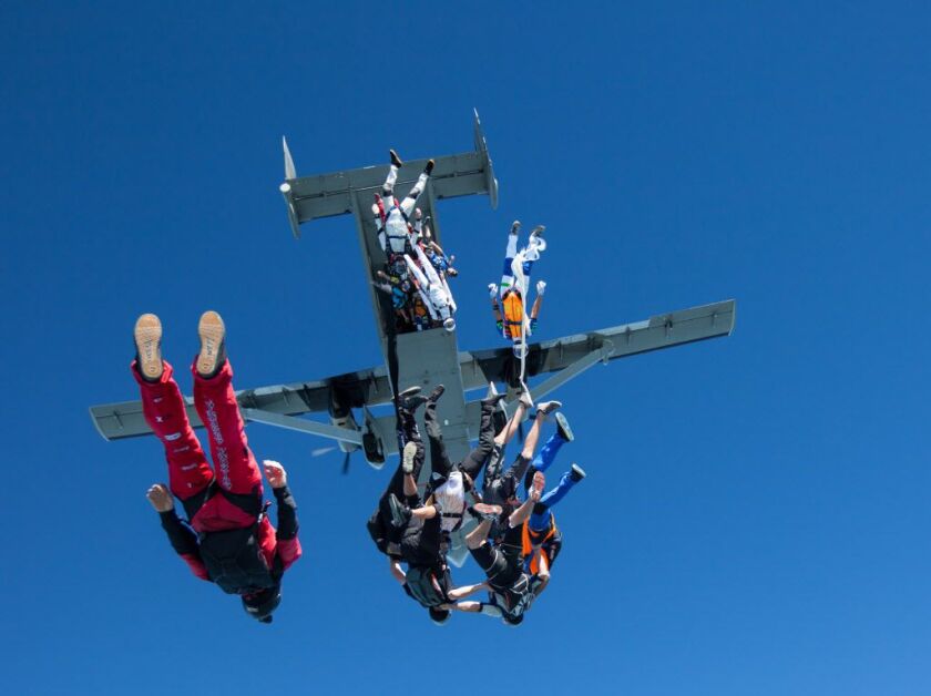 In this photo provided by Jason Peters, members of an international team of skydivers exit a jump plane flying head-down on their way to building their world record skydiving formation Friday, July 31, 2014, over Ottawa, Ill. It took the team 13 attempts