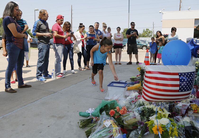 Kayleigh Martinez places coins in a donation box at a makeshift memorial for Harris County Sheriff’s Deputy Darren Goforth Saturday. James Nielsen/Houston Chronicle via AP