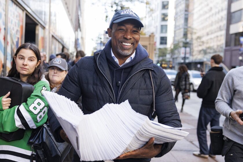 Former Chicago Housing Authority board chair Matthew Brewer hauls a stack of nominating petitions into the Chicago Board of Elections office Monday as he files to run in the 2027 mayoral election.