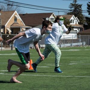 Student Mike Burke and teacher Mary Gibson run towards a wading pool filled with snow and water for St. Patrick High School’s version of the Polar Plunge.