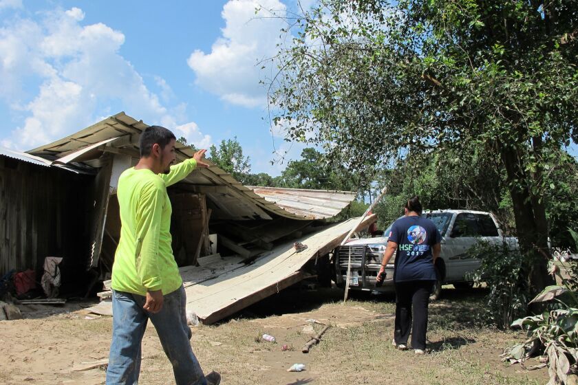 Rafael and Silvia Casas tour the wreckage of their family home near the San Jacinto River in Crosby, Texas on Friday. | Jason Dearen/Associated Press