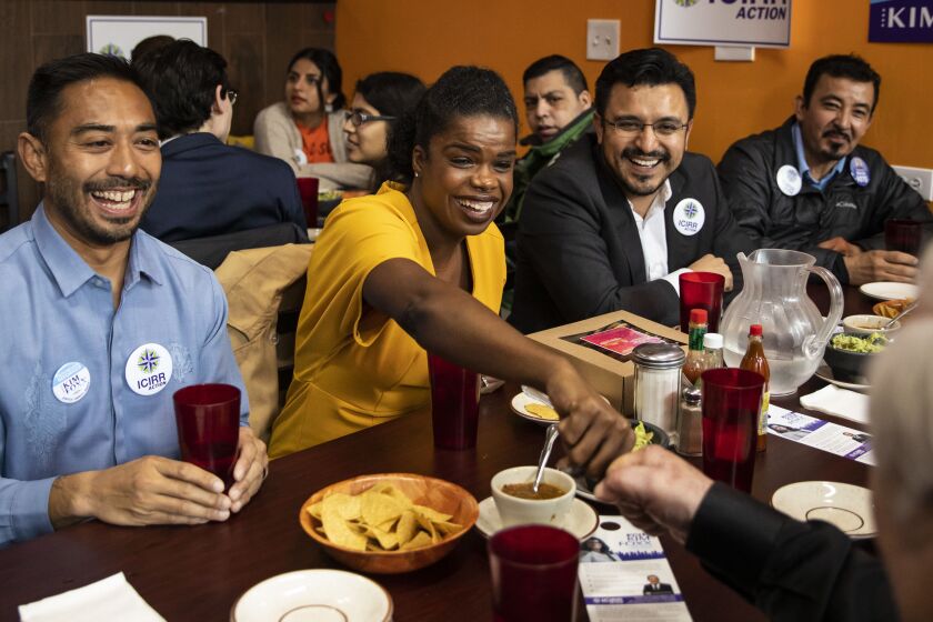 About a week before the March Primary, Cook County State’s Attorney Kim Foxx fist bumps a supporter during a campaign stop at Cecina Grill in Pilsen.