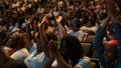 Teens raise their hands inside the Harris Theater during My Block, My Hood, My City's Downtown Day event on July 11, 2026.