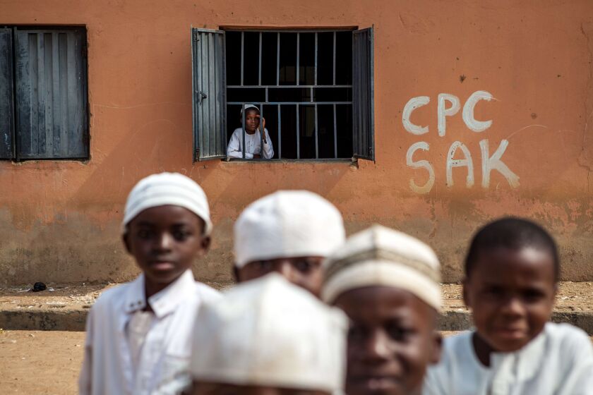 A student of the local Madrassa looks from a window while other students play in the courtyard in Kaduna on January 21, 2015. FLORIAN PLAUCHEUR/AFP/Getty Images