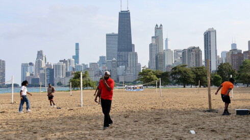Youth hang out on the beach with the Chicago skyline in the background.