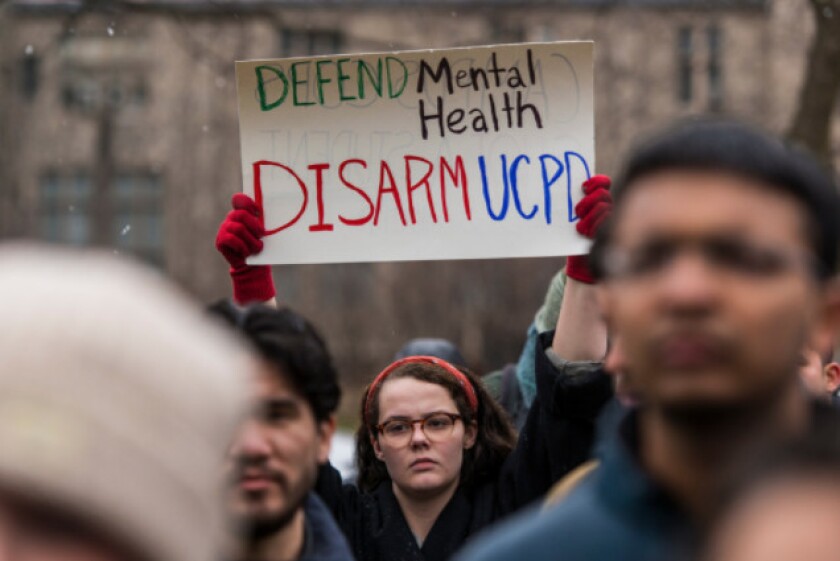 Activists gather in front of the University of Chicago’s Booth School of Business building to protest the shooting of student Charles Thomas.