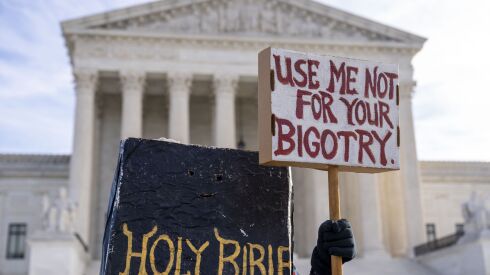 A person dressed as a Bible protests outside the Supreme Court in Washington on Monday, Dec. 5, 2022, where the Supreme Court heard the case of a Christian graphic artist who objects to designing wedding websites for gay couples.